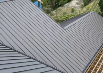 Nielsen Roofing installing new grey residential metal roof near Penticton